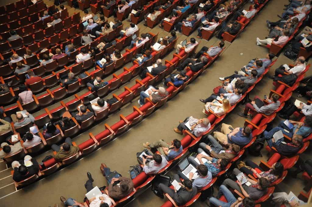 A birds-eye view of people sitting in theater seats. 