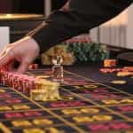 A casino dealer places chips on the table.