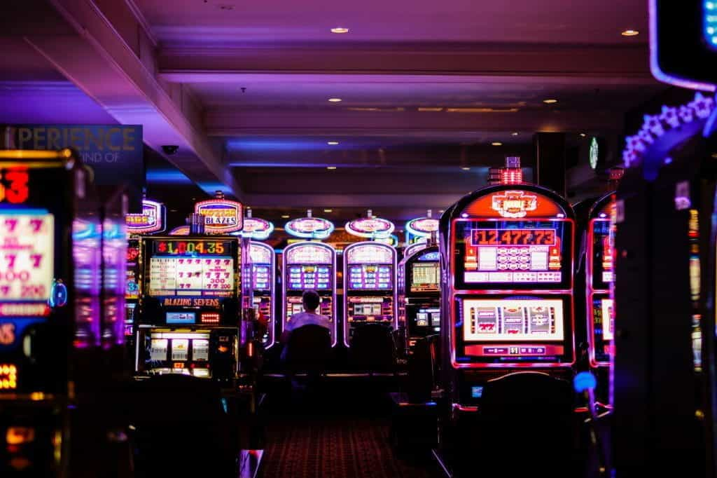 Slot machines glowing with neon lights on a casino floor.