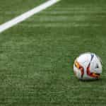 A football on a grass pitch.