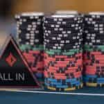 Chips and an ‘All IN’ dealer button on a poker table.